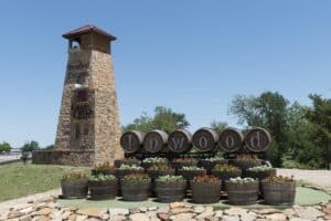 Wine barrels and a stone tower marking a winery entrance on the US-290 wine road near Fredericksburg, Texas