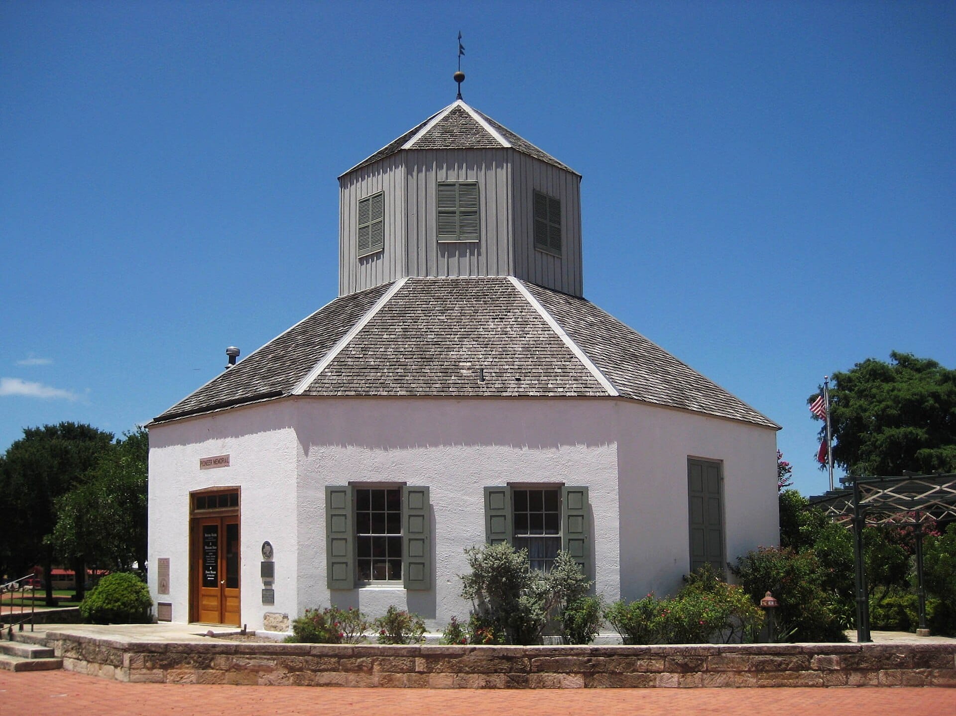 The white octagonal Vereins Kirche building with its shingled roof and cupola on Marktplatz in Fredericksburg, Texas